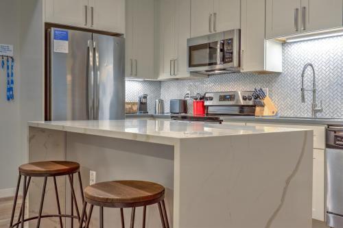 a kitchen with a counter and two stools at Kasa Forest Park St Louis in Maryland Heights