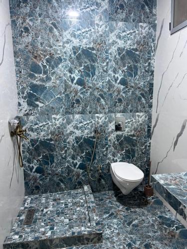 a bathroom with a toilet and a blue marble wall at Casablanca heart of town apartment in Casablanca