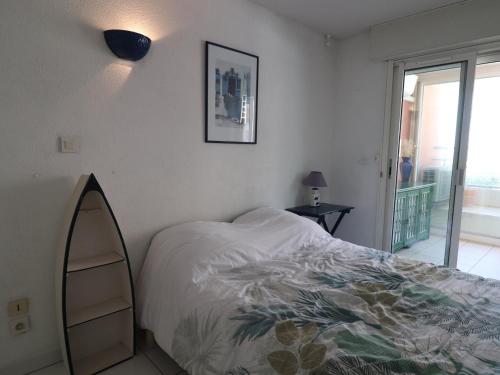 une chambre avec un lit, un miroir et une fenêtre dans l'établissement Appartement climatisé avec loggia, 2 pièces, 4 pers, 2 Clés vacances à Sète - FR-1-472A-248, à Sète
