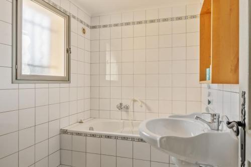 Baño blanco con lavabo y bañera en Villa Piscine, vue mer Cap Nègre, en Le Lavandou