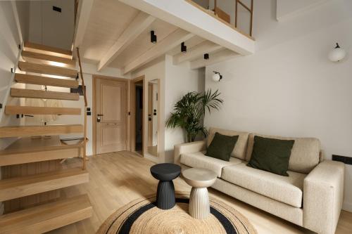 a living room with a couch and a staircase at Cortiletto Timeless Suites in Rethymno