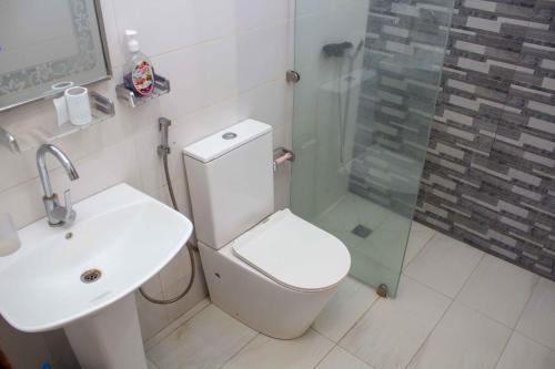 uma casa de banho com um WC, um lavatório e um chuveiro em Happyhomes em Dakar