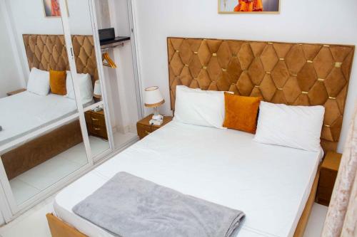 1 dormitorio con 1 cama grande y espejo en Happyhomes en Dakar