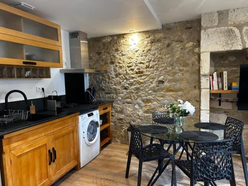 une cuisine avec une table et une machine à laver dans l'établissement La Joaillerie, à Bourges