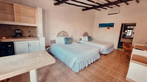 a bedroom with two beds and a kitchen with a counter at Hotel Margarita Village in Porlamar