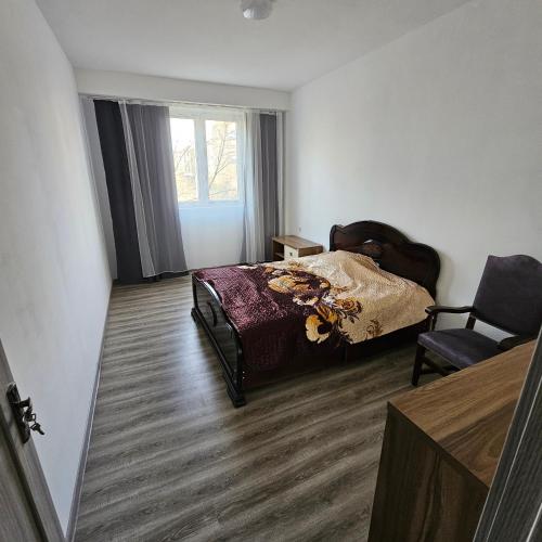 una camera con un letto e una sedia e una finestra di koberidze a Kutaisi