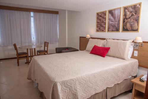 a bedroom with a large bed with a red pillow at Sol Victoria Marina in Salvador