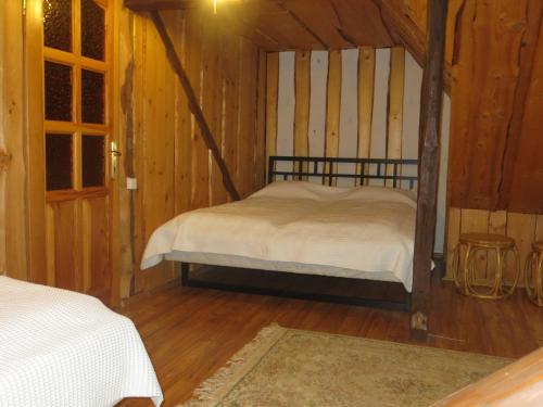a bedroom with a bed in a wooden cabin at Sodyba Brazylija in Taraldžiai