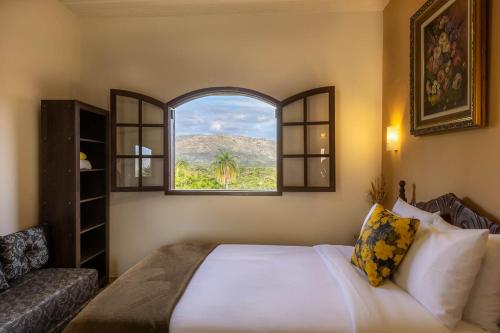 a bedroom with a large bed and a window at Pousada Belvedere da Serra in Serra do Cipo