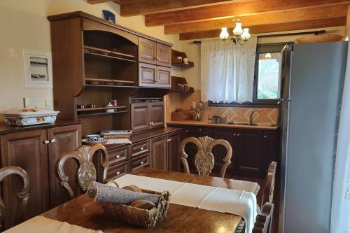 cocina con mesa de comedor y nevera en Agnes Cottage House, en Konitsa