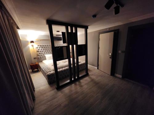 Konak的住宿－TALLES CITY HOTEL，一间卧室配有一张床和一面大镜子