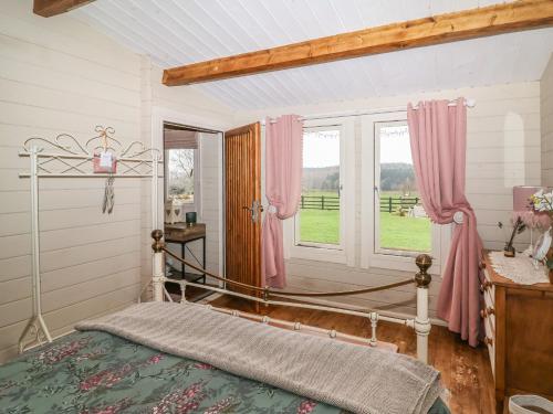 um quarto com uma cama com cortinas cor-de-rosa e uma janela em Westfield Lodge em York
