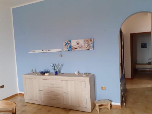 a room with a blue wall with a dresser at LA FINESTRA SUL MARE in Trappeto