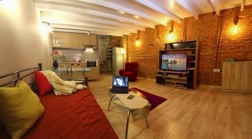 a living room with a red couch and a tv at Ionia rooms in Chios