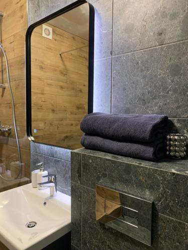 a bathroom with a sink and a mirror at Дизайнерські апартаменти в ЖК DreamTown 10а in Luts'k