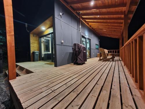 a large wooden deck with a backpack sitting on it at Tiny & Big House Suite Los Mallines de Malalcahuello in Malalcahuello