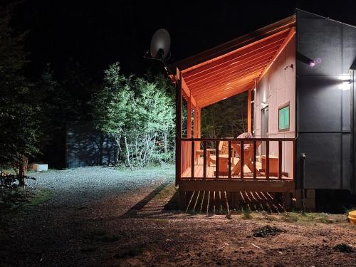 a small house with a porch at night at Tiny & Big House Suite Los Mallines de Malalcahuello in Malalcahuello