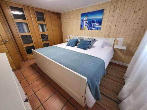 Un dormitorio con una gran cama blanca con almohadas azules. en Apartamento El Olivo, en Vigo