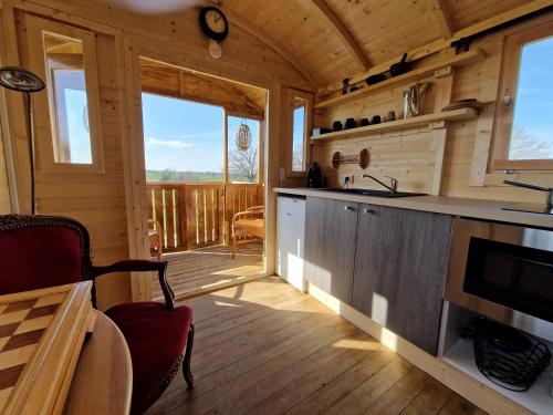 uma cozinha e sala de estar de um chalé de madeira em Roulotte La Maison Des Trois Grands em Sannat