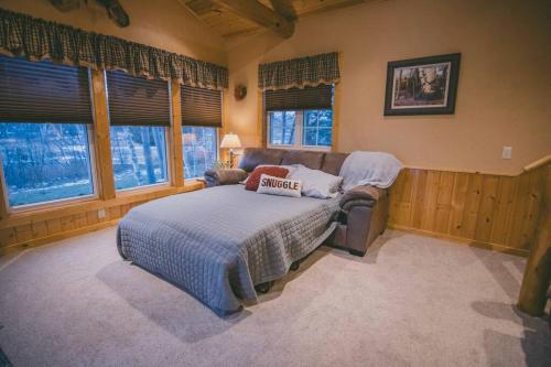 a bedroom with a bed and a couch and windows at Wilson Flowage Cabin ~Sauna~Fire Pit~Kayaks in Phillips