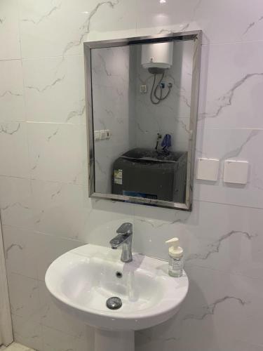 lavabo blanco en el baño con espejo en Singles Room en Yeda