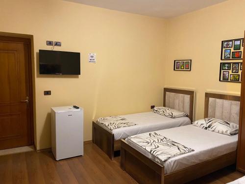 Habitación con 2 camas y TV en la pared. en Vila Haznedari en Berat