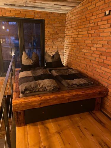 a bed in a room with a brick wall at Ferienwohnung Loft Schwielowsee mit Sauna in Schwielowsee
