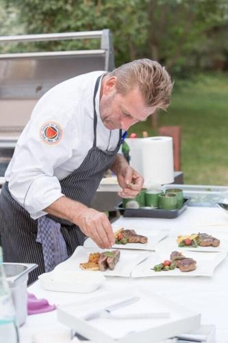 a man is preparing food on a table at Restaurant Niedmühle Land & Genuss Hotel in Rehlingen-Siersburg
