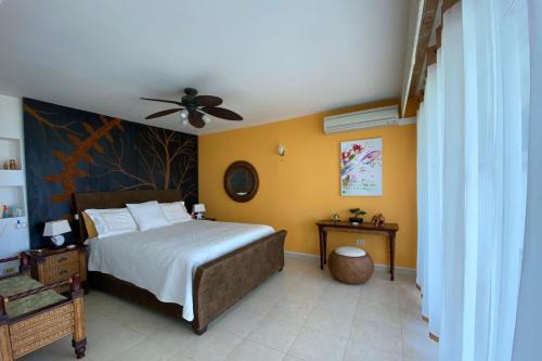 a bedroom with a bed and a ceiling fan at Villa Jambalaya in Maho Reef