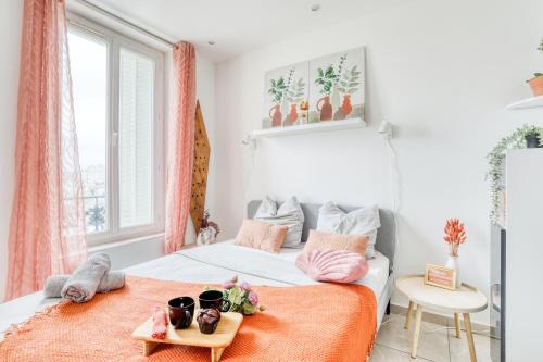 - une chambre avec un lit et une couverture orange dans l'établissement Le Sweet Nook - métro mairie de Montreuil, à Montreuil