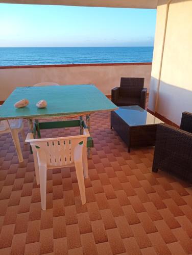 une table et des chaises avec l'océan en arrière-plan dans l'établissement la finestra sul mare piano 2, à Trappeto
