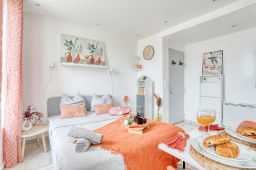 une pièce avec un lit et une table avec de la nourriture dessus dans l'établissement Le Sweet Nook - métro mairie de Montreuil, à Montreuil