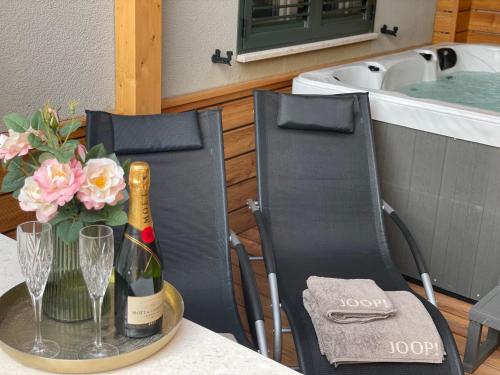 a table with two chairs and a bottle of champagne and flowers at Gabrijel Apartments Makarska 2 in Makarska