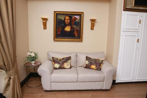 a living room with a couch with a painting on the wall at Villa Grande Luxury accommodation in Welkom