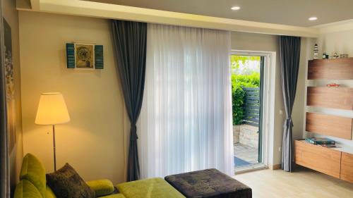 a living room with a green couch and a window at Gabrijel Apartments Makarska 2 in Makarska