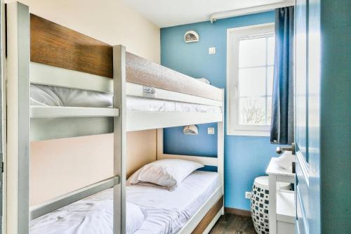 ein Zimmer mit zwei Etagenbetten und einem Fenster in der Unterkunft Les Maisons de Belle Dune - maeva Home - Maison 4 pièces 6 personnes Prestige MAE-2648 in Fort-Mahon-Plage
