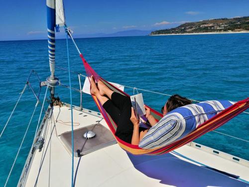 a woman laying in a hammock on a boat at XSail mediterraneo sport experience in Piombino