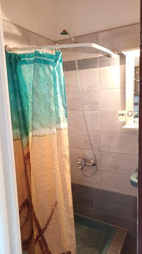 a shower with a colorful shower curtain in a bathroom at Tasia Studios in Perivolion