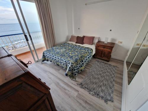 a bedroom with a bed and a view of the ocean at Bajamar Oasis in Bajamar