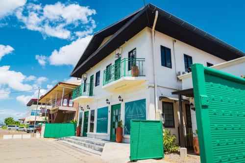 un edificio blanco con balcones verdes en una calle en Cozy and quirky Wolf Apartment, en Paramaribo
