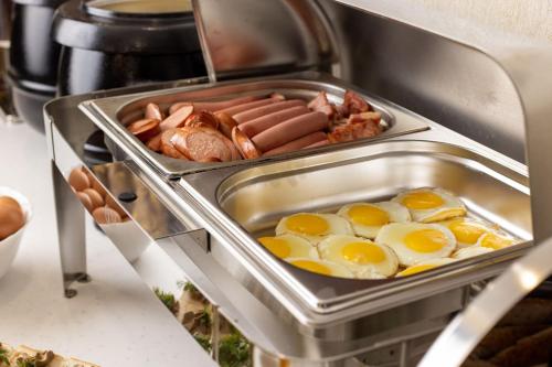 a breakfast tray with eggs and sausage in a kitchen at - Granada - Boutique Hotel - Tbilisi - in Tbilisi City