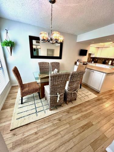 a dining room with a glass table and chairs at Luxury Waterfront Views - Heated Pool - 1400sf Duplex - Minutes to the Beach in Siesta Key