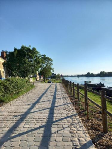 Une longue ombre d'une rue à côté d'une rivière dans l'établissement La Halte des Bateliers et des Vignobles, à Rochefort-sur-Loire