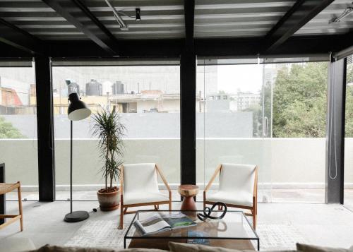 a living room with two chairs and a glass table at Elba By Mr W in Mexico City
