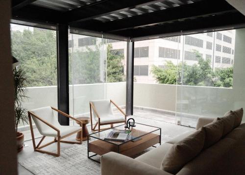 a living room with a couch and chairs and windows at Elba By Mr W in Mexico City