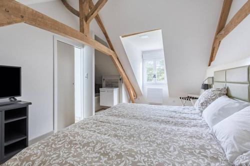 1 dormitorio blanco con 1 cama grande y TV en Maison avec Terrasse - 2 chambres confortables pour 4 à 6 personnes, en Verton