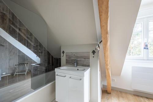 Baño blanco con lavabo y escalera en Maison avec Terrasse - 2 chambres confortables pour 4 à 6 personnes, en Verton