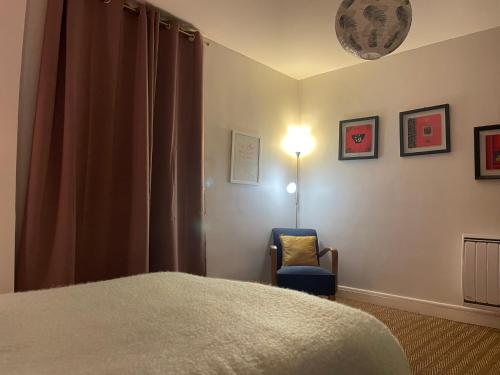 une chambre avec un lit, une chaise et une lampe dans l'établissement La Halte des Bateliers et des Vignobles, à Rochefort-sur-Loire