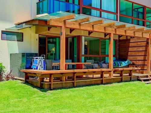 a house with a wooden deck with a bench at Reserva dos Carneiros - Flat-Apartamento em Carneiros in Tamandaré
