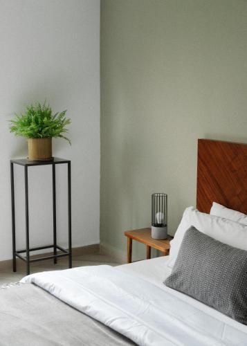 a bedroom with a bed and a plant on a table at Elba By Mr W in Mexico City
